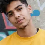 Jovem de cabelo escuro e camiseta amarela, inscrito do PW Club
